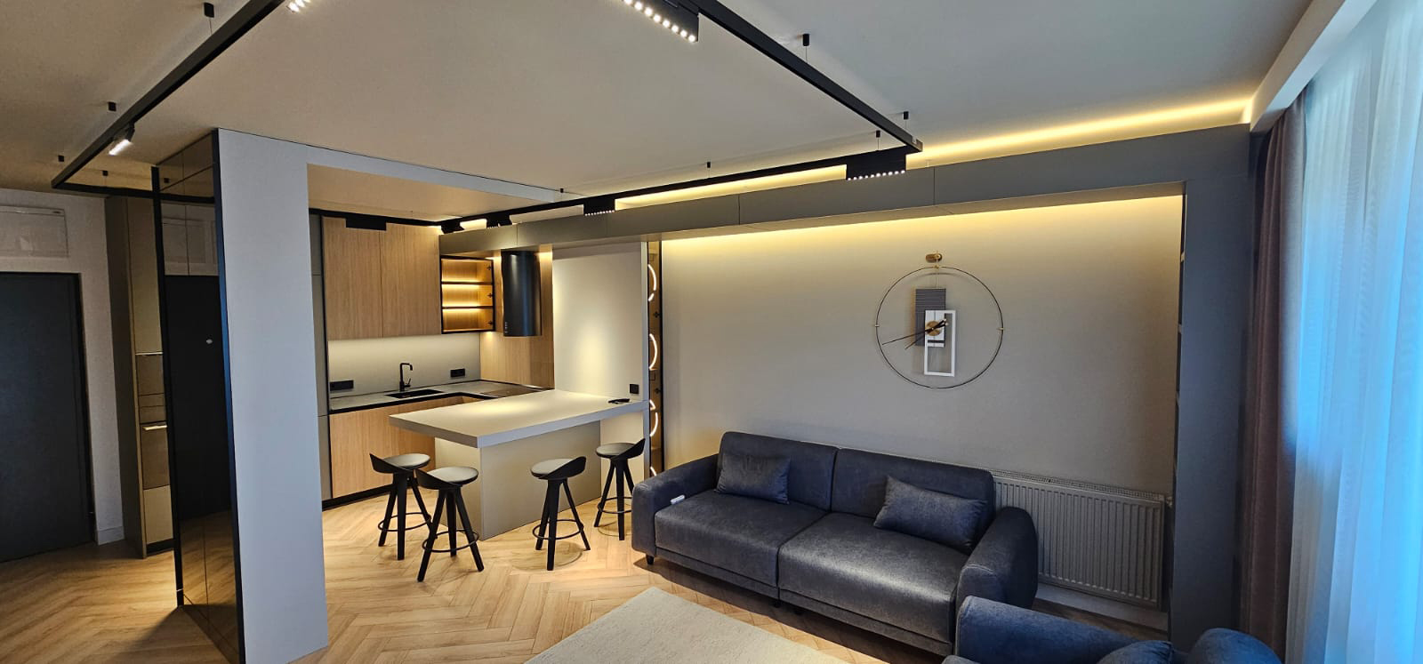 Bucătărie open-space Master Oak cu living, parchet chevron și iluminat arhitectural