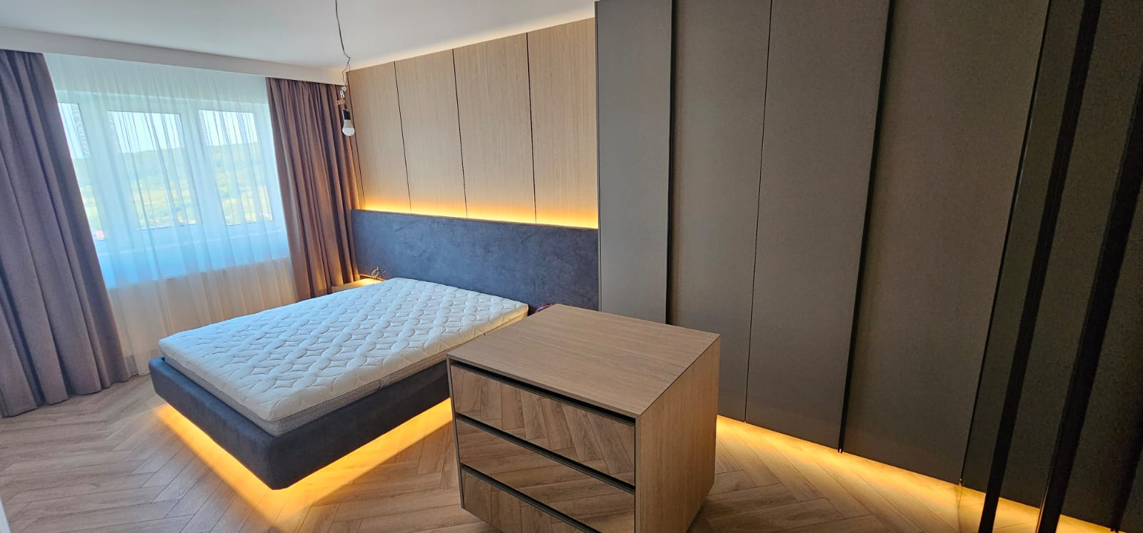 Dormitor amenajat cu mobilier Master Oak, dulap încorporat și parchet chevron